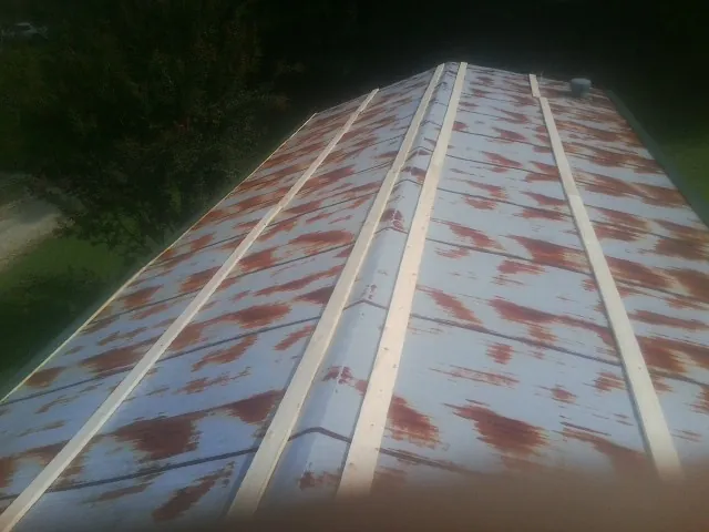 Rusted metal roof panels with new wood purlins before replacement — Storm Damage Roof Repair in Roundup by Roofing Brothers